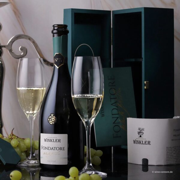 Winkler Fondatore sparkling wine bottle and two glasses with light bubbles, grapes, and a gift box.