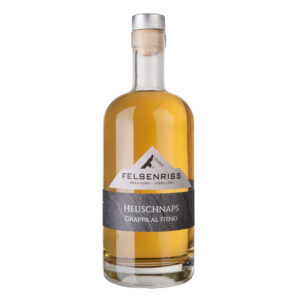 Bottle of Felsenriss Heuschnaps Grappa Al Fieno, a spirit with a mountain label and a light amber color.