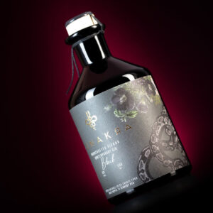 Bottle of Unakkaa Vienna Black Contemporary Gin with snake graphic and floral accents on the label against a red background.