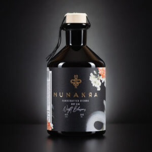 A sleek bottle of Munakra Handcrafted Vienna Dry Gin 'Night Blossoms' with a black label and floral accents.