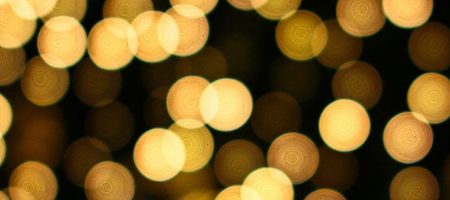 Blurred golden lights on a dark background, suggesting a festive or celebratory atmosphere.